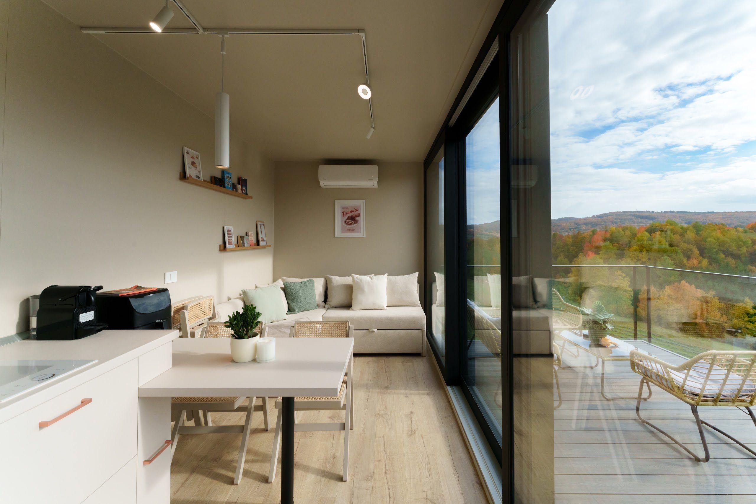 Living area with panoramic windows opening onto the deck in the Tiramisu tiny house
