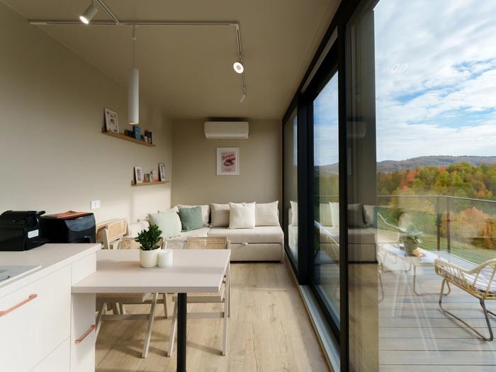 Living area with panoramic windows Living area with panoramic windows opening onto the deck in the Tiramisu tiny house