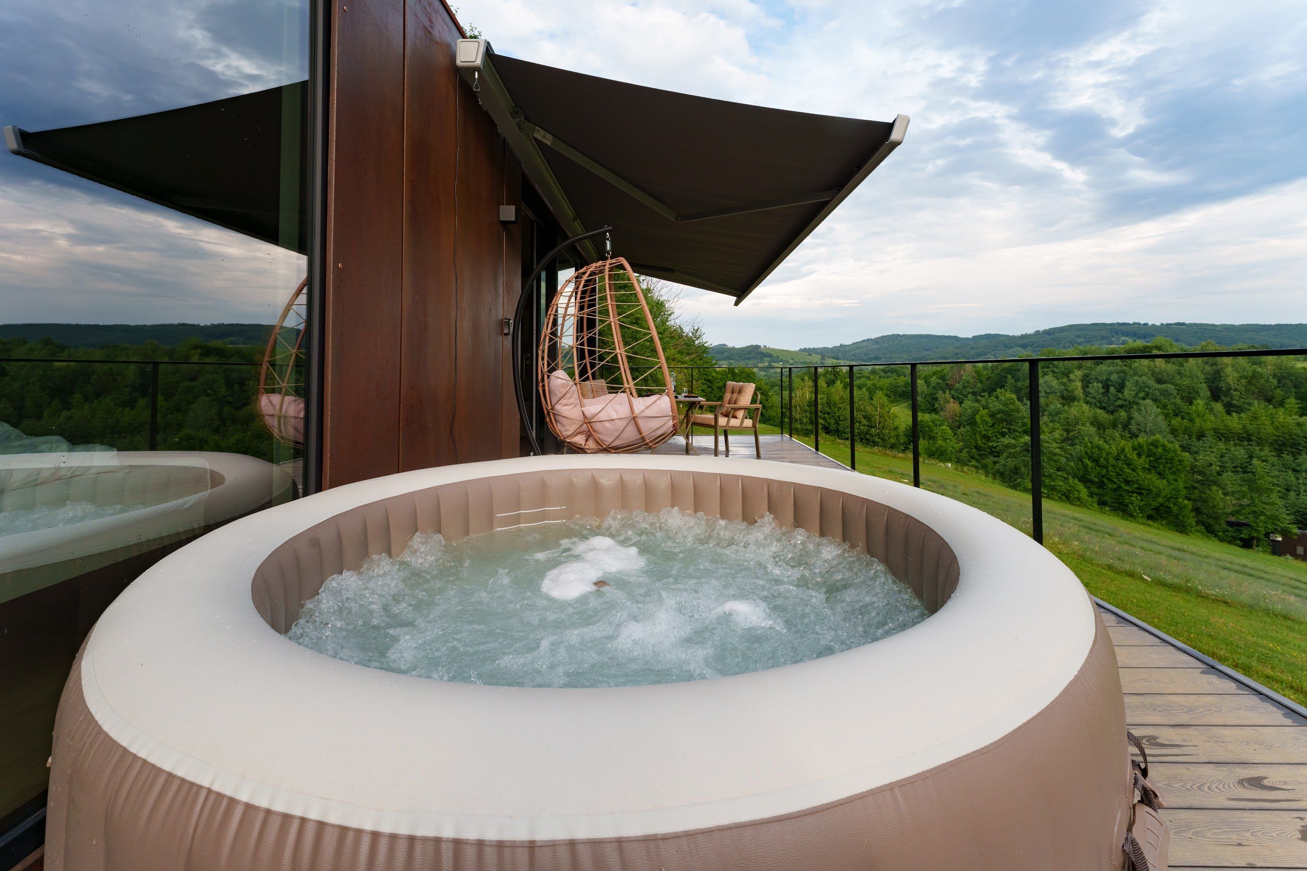 Private deck with heated hot tub at the Tiramisu tiny house, overlooking the forest