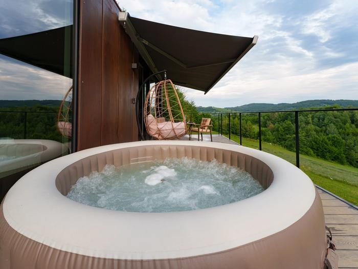 Deck with heated hot tub Private deck with heated hot tub at the Tiramisu tiny house, overlooking the forest