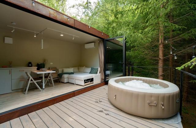 Terasa cu jacuzzi încălzit a tiny house-ului Luna, în pădurea de brazi
