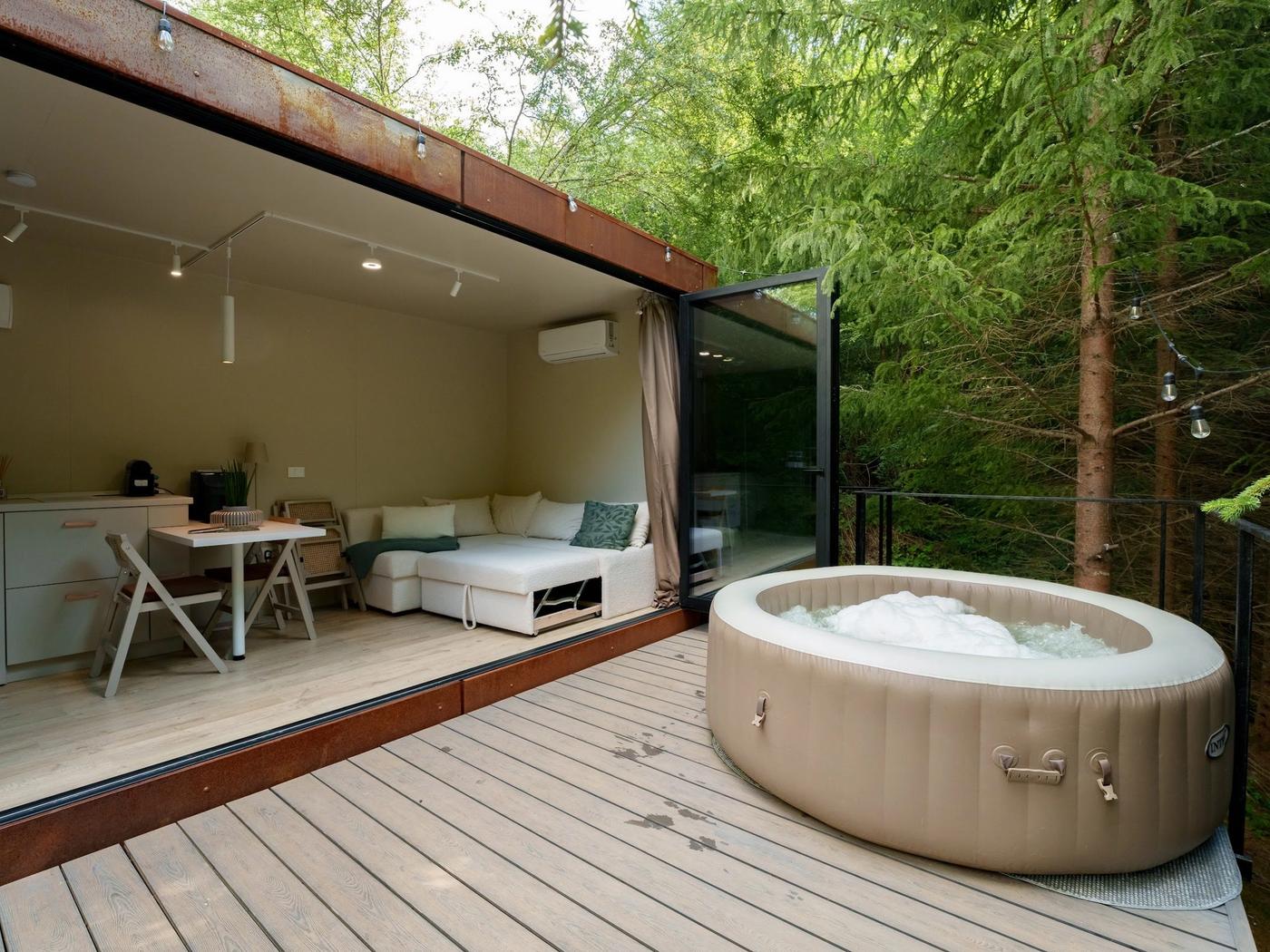 Deck with hot tub in the forest The deck with heated hot tub at the Luna tiny house, inside the fir forest