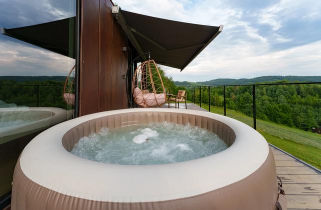 Jacuzzi pe terasa căsuței Tiramisu, cu vedere spre dealuri