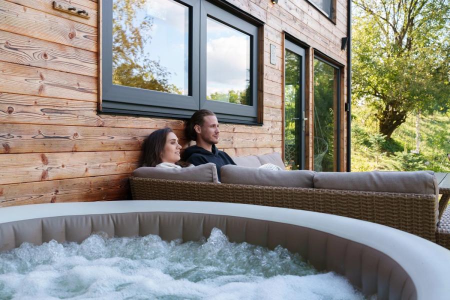 Hot tub on the panoramic terrace of the Hypo tiny house with a mountain view