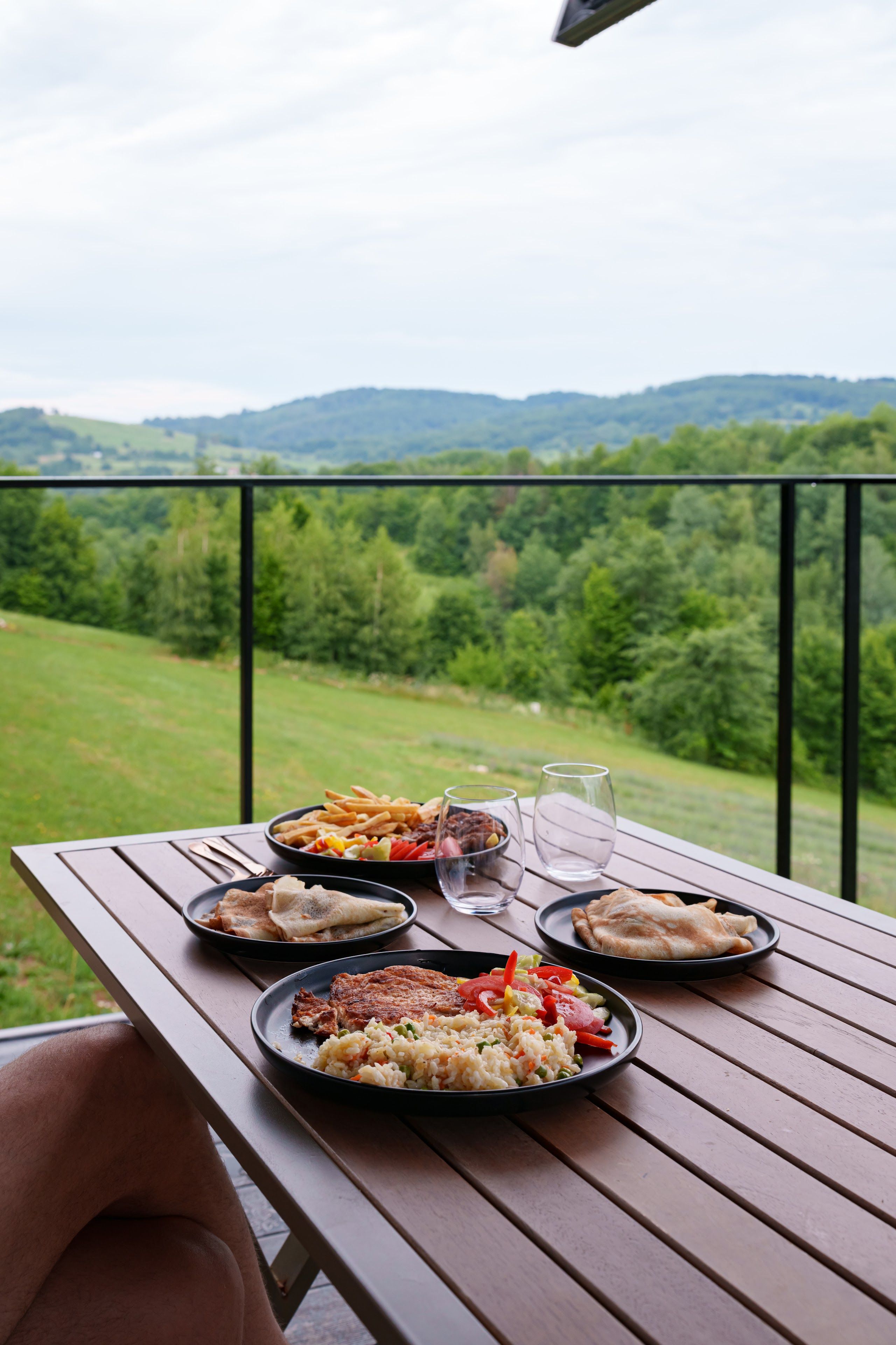 Meal served on the terrace of a Coniferis Retreat cabin, overlooking the forested hills of the Apuseni Mountains