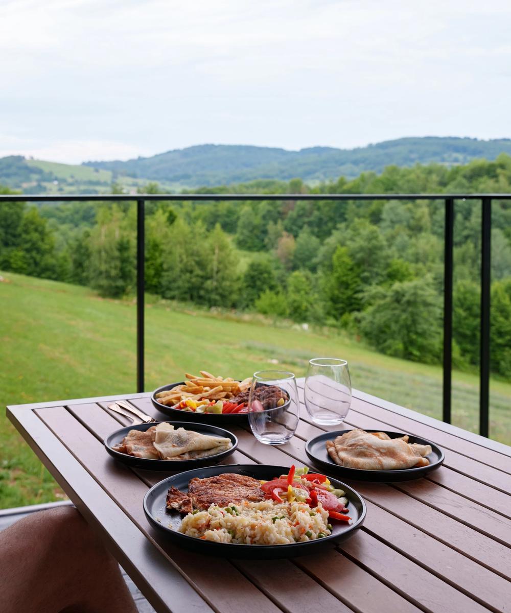 Lunch on the terrace overlooking the hills Meal served on the terrace of a Coniferis Retreat cabin, overlooking the forested hills of the Apuseni Mountains