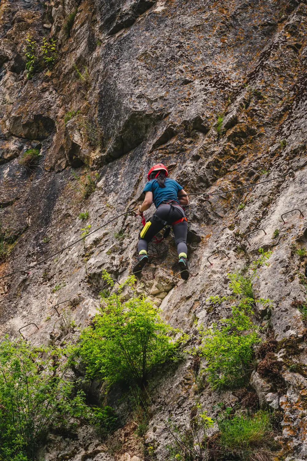 A climber with helmet and harness on the „Peretele Zânelor” via ferrata route