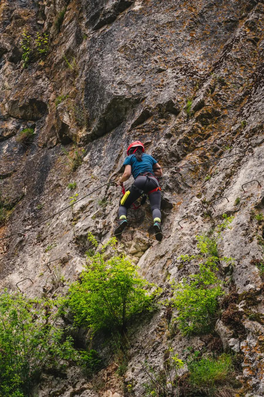 A climber with helmet and harness on the „Peretele Zânelor” via ferrata route