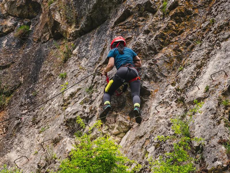 A climber with helmet and harness on the „Peretele Zânelor” via ferrata route