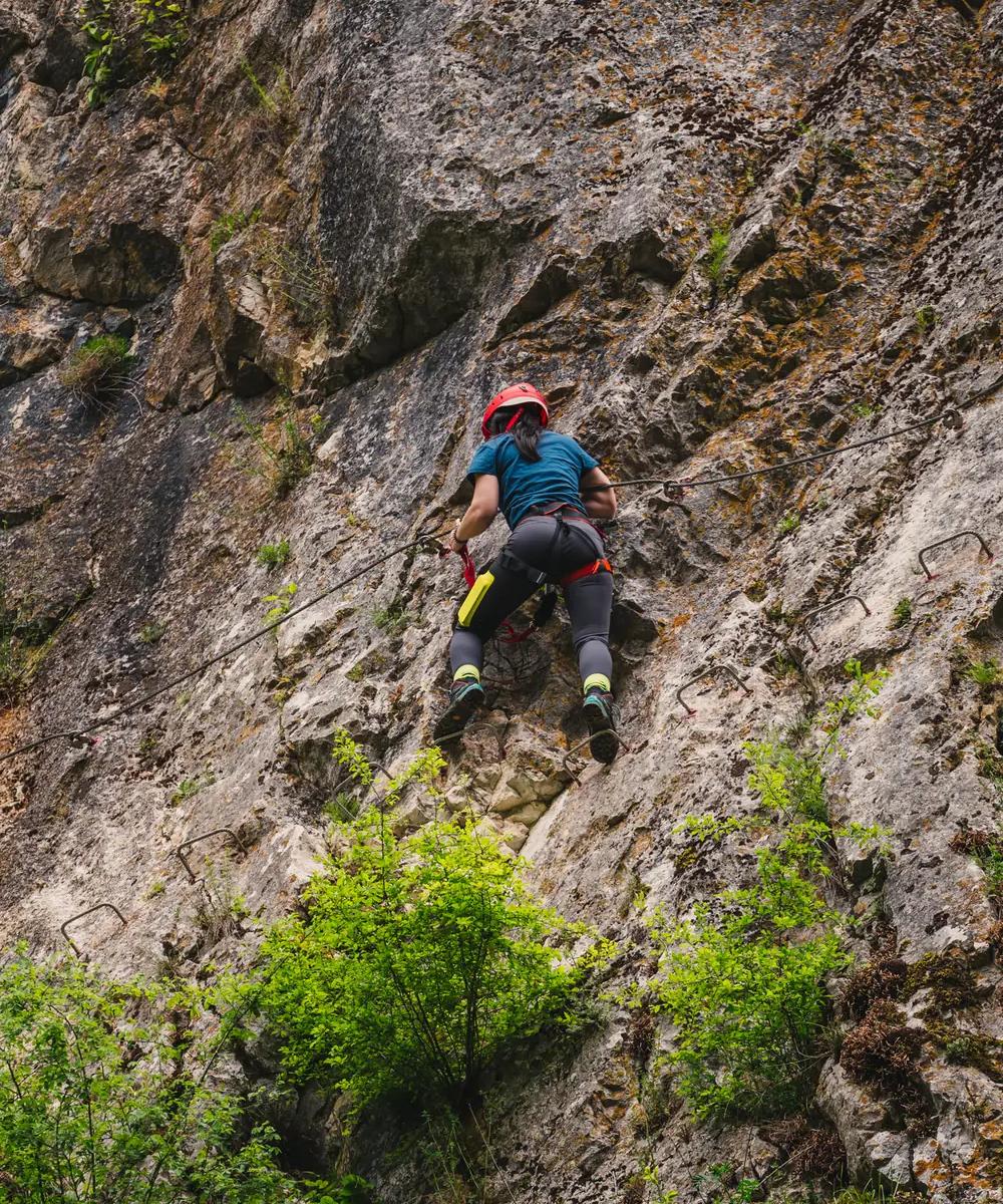 Via Ferrata — Fairy Wall A climber with helmet and harness on the „Peretele Zânelor” via ferrata route