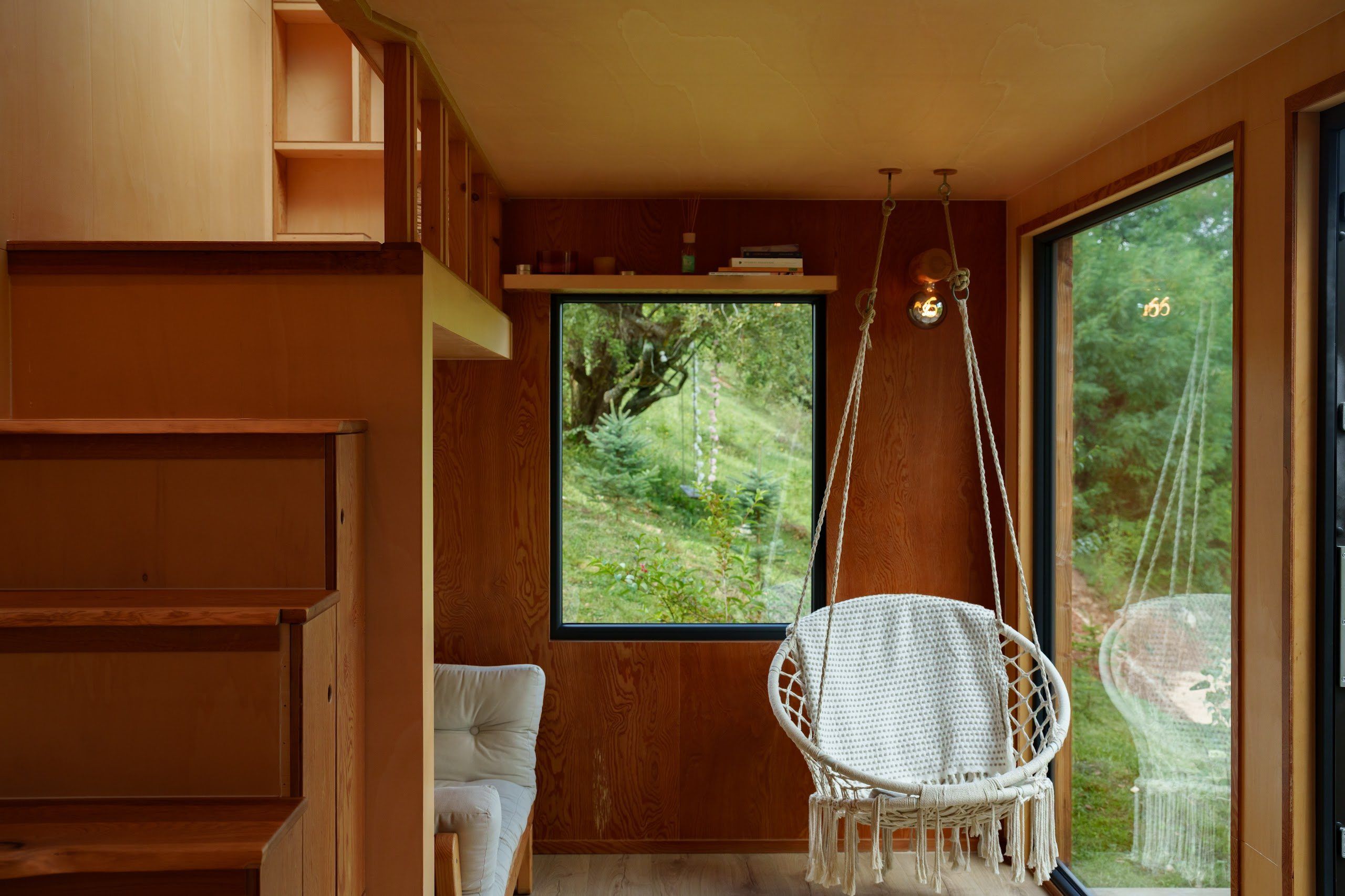 Hanging chair with forest view inside the Hypo cabin