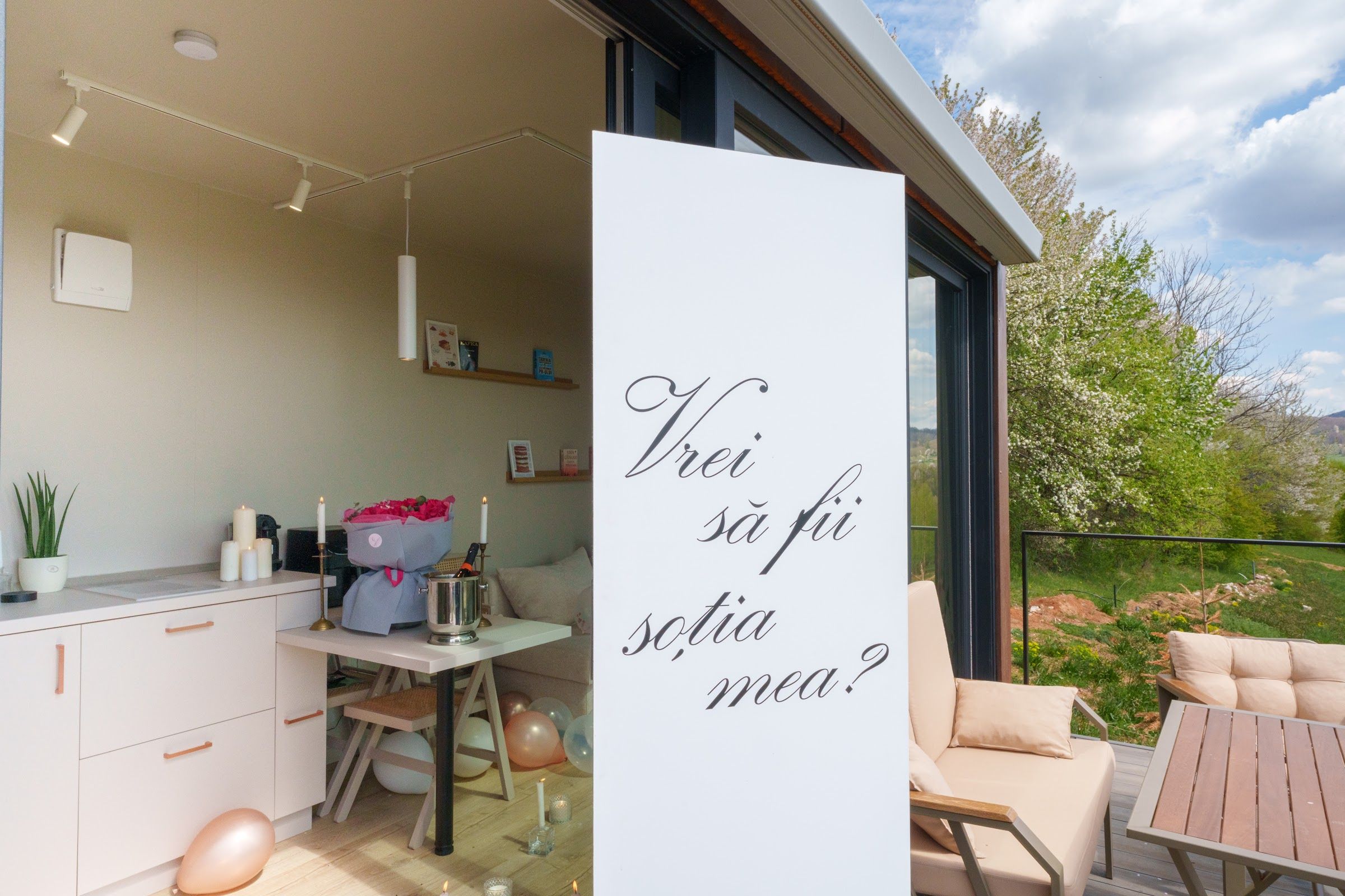 Marriage proposal setup with a "Will you marry me?" sign, roses, candles and balloons at Coniferis