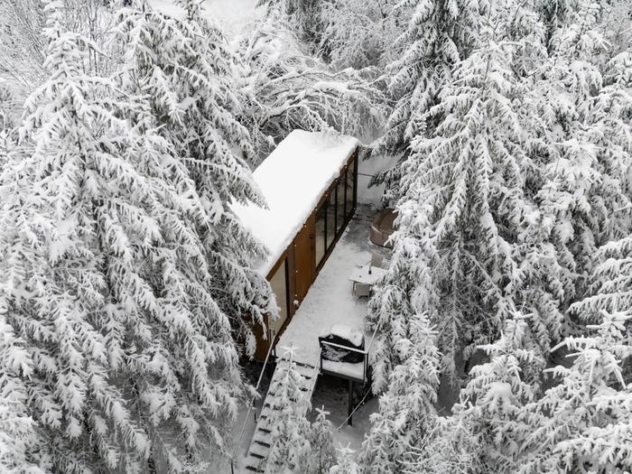 Luna in winter – aerial view Aerial view of the Luna cabin hidden in the snowy fir forest of the Apuseni