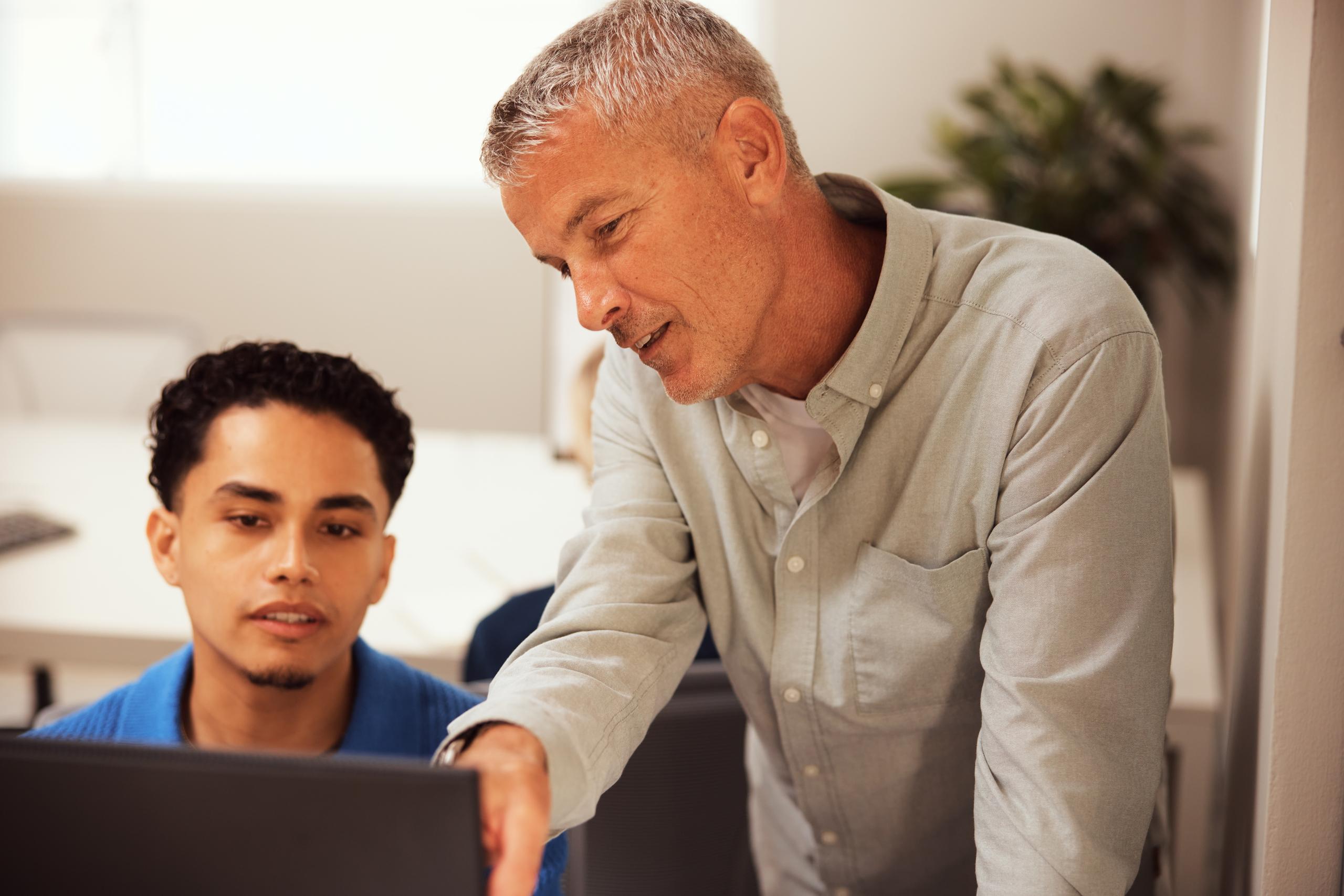 Two people talking at a desk