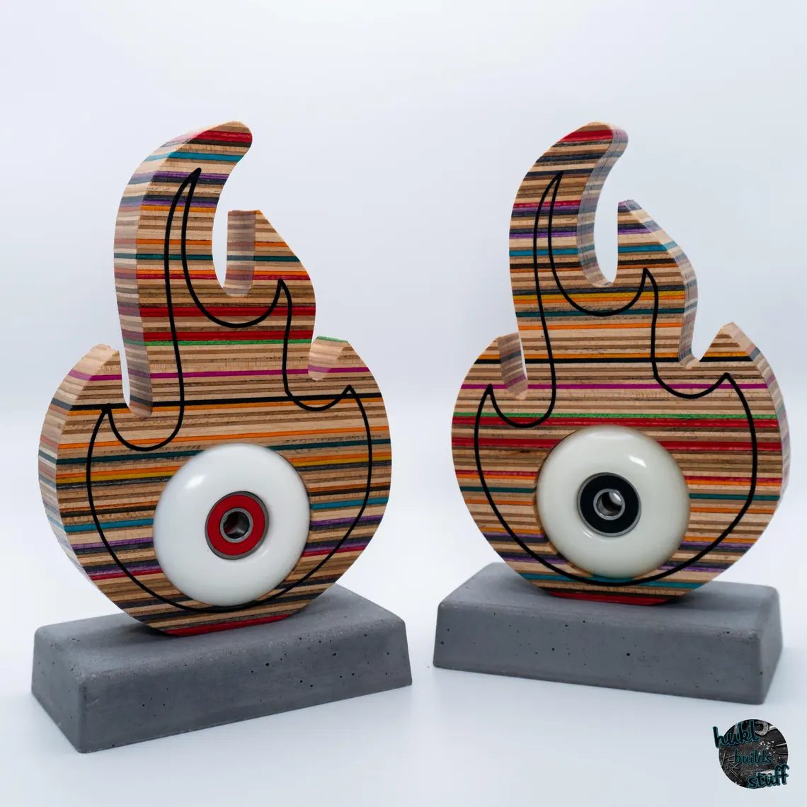 A sculpture combining recycled skateboard decks, a skateboard wheel and a concrete base, exploring the materials and energy of skateboarding.