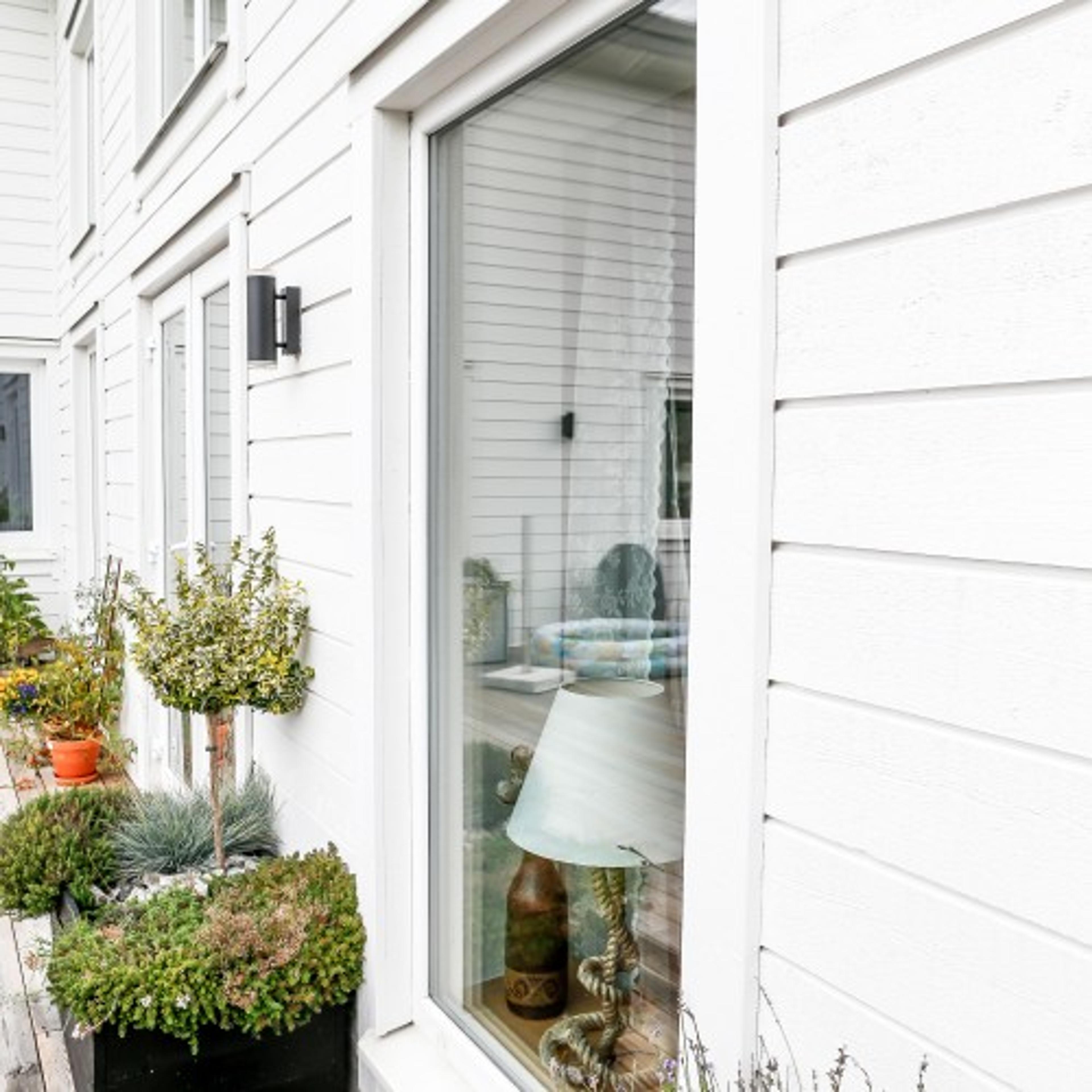 Vita PVC-Fönster på blir snyggt mot husfasad med liggande träpanel