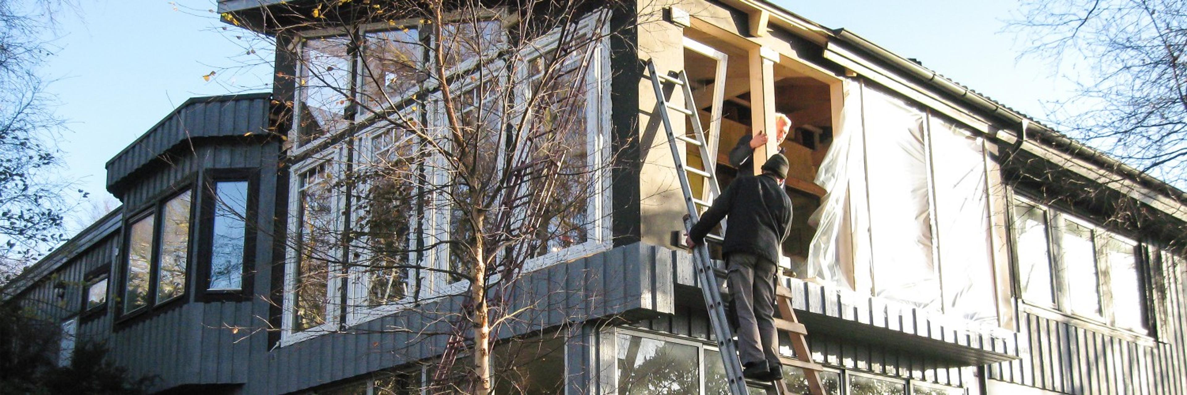 Hantverkare monterar Menta fönster i grå villa
