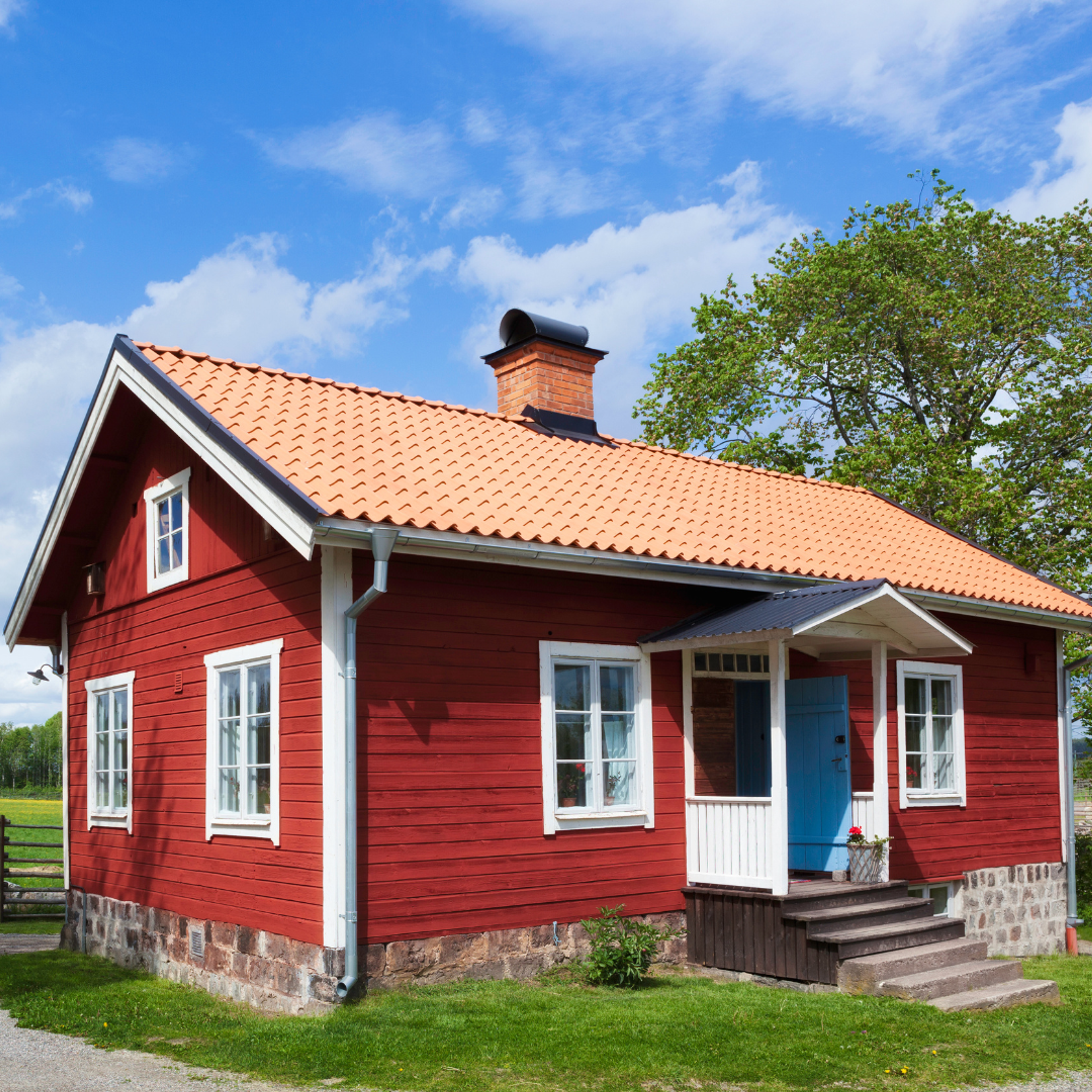 Rött hus med äldre fönster Rött hus på landet med vita knutar