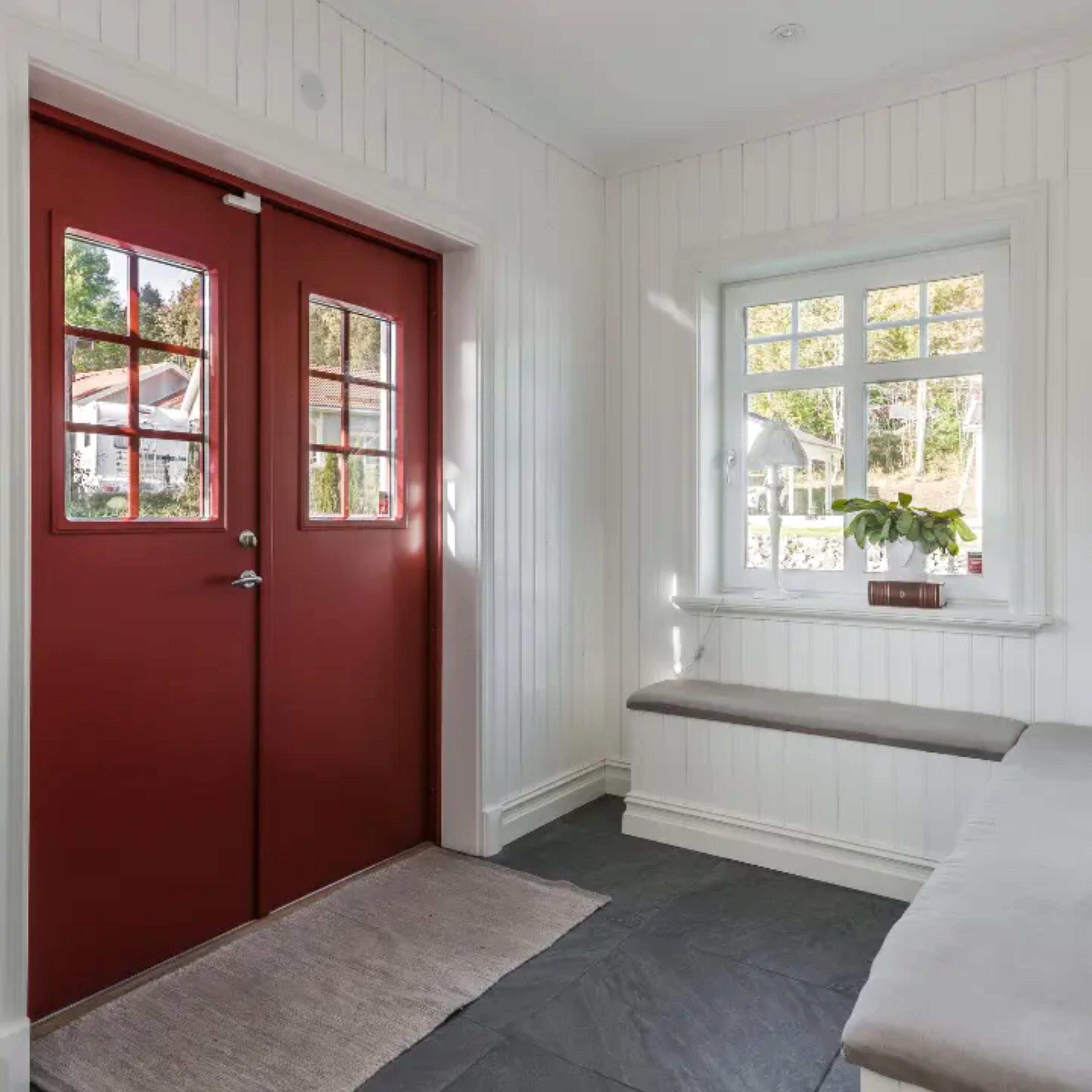 Menta fönster PVC fönster i hall med röd entrédörr