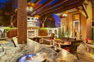 An outdoor counter with a firepit and wine glasses. An outdoor fireplace, dining room, and ourdoor kitchen. 