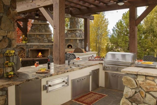 Outdoor kitchen with grill, sink, and marble counter