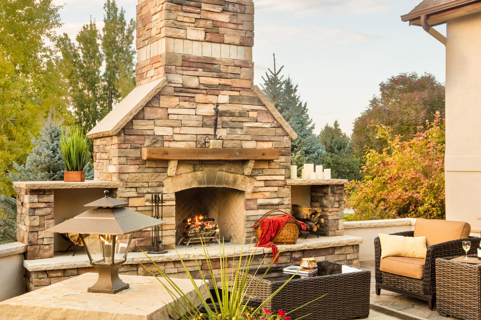 Outdoor fireplace with wood mantle and gas lanterns