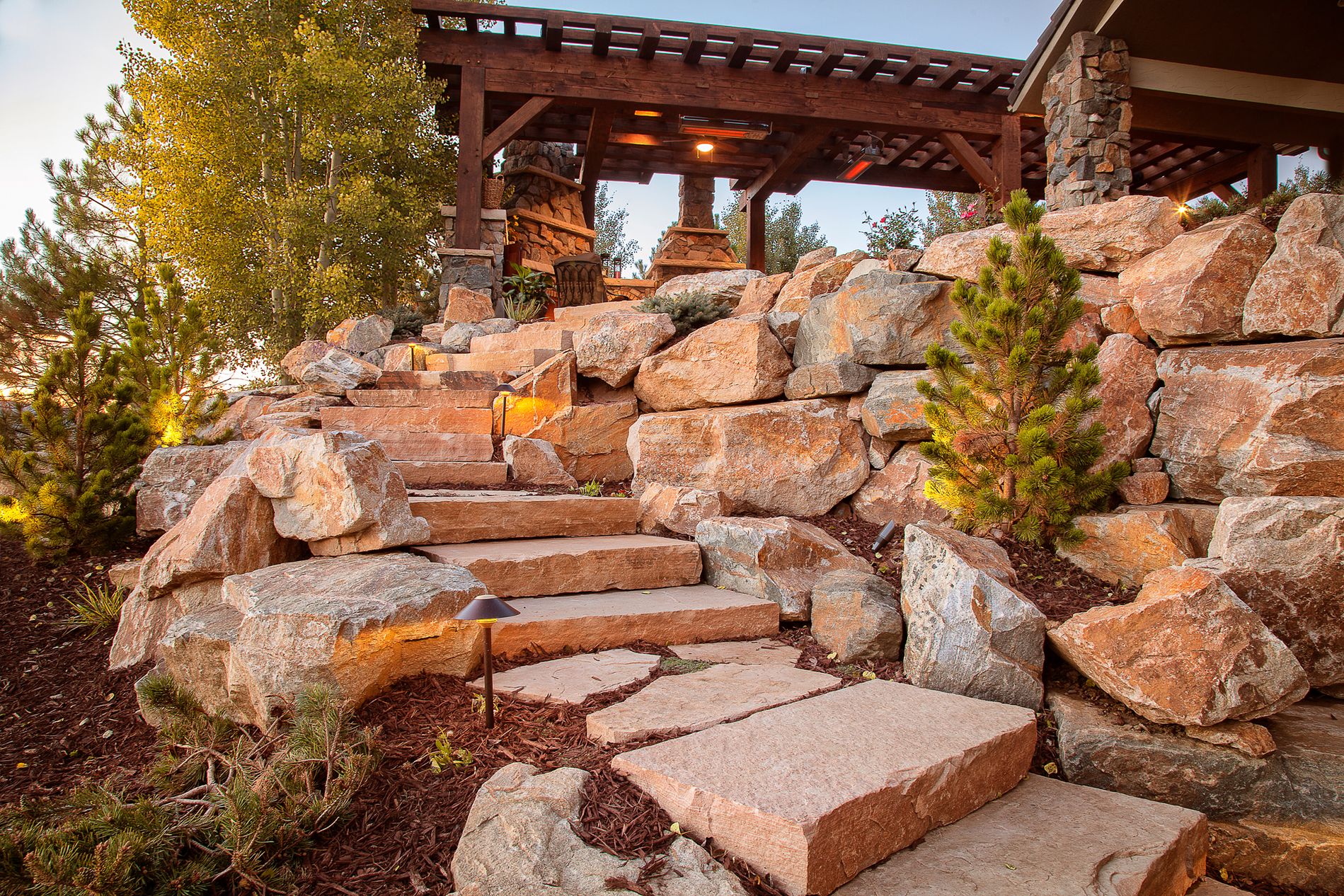 Sandstone slab staircase with boulder retaining wall and landscape lighting