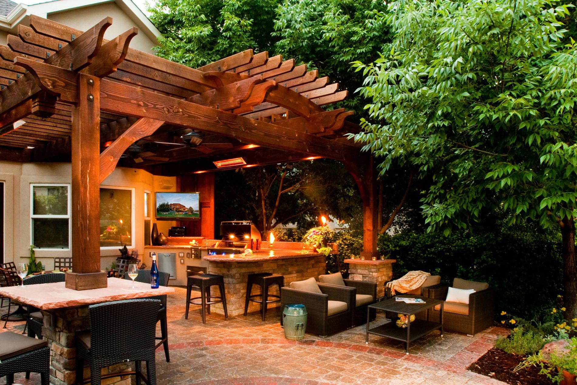 Outdoor Kitchen With Paver Patio and Shade Structure at Night