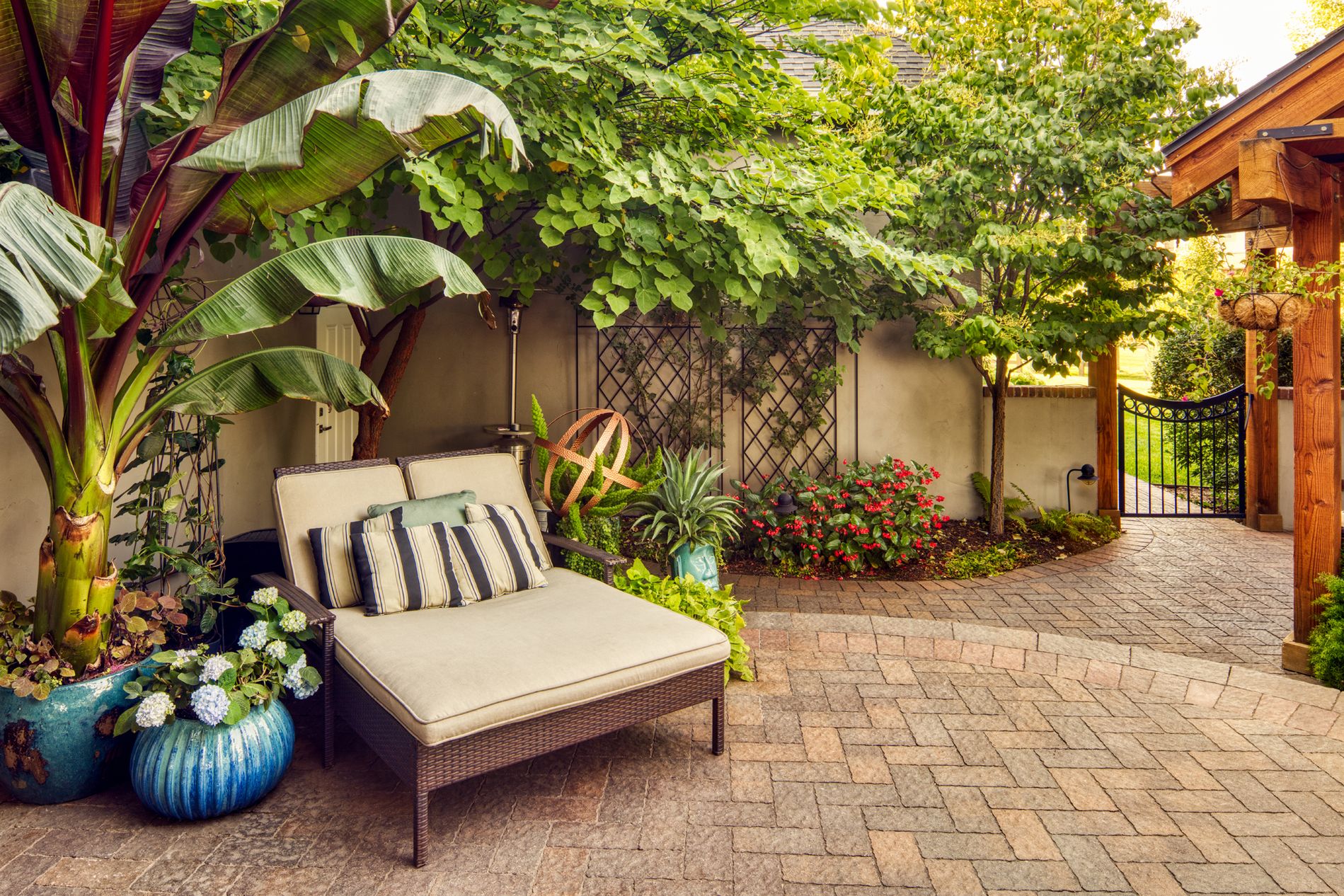 Paver patio and lounge chair in backyard courtyard