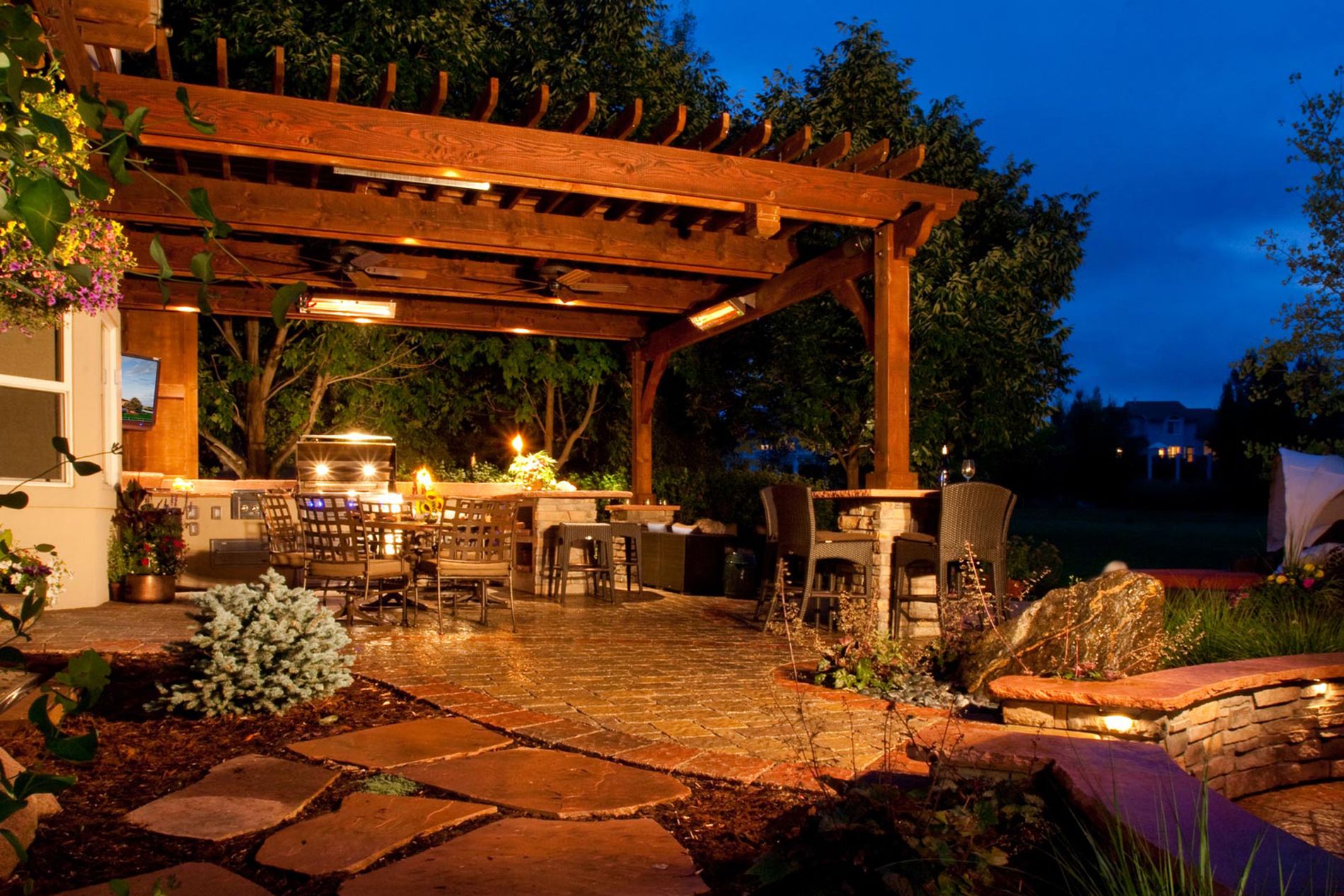 Outdoor Kitchen With Paver Patio and Shade Structure with Landscape Lighting