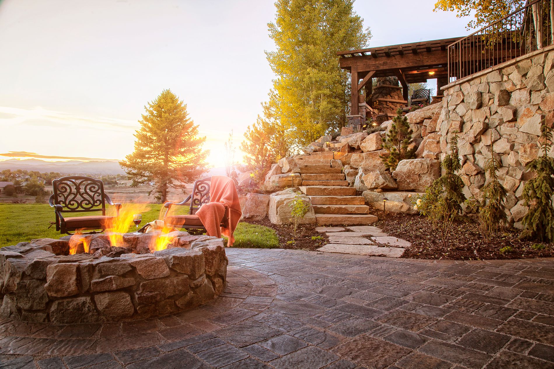 Fire pit and sandstone slab staircase and retaining wall with paver patio