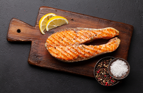 salmon on cutting board | foods that help with muscle cramps