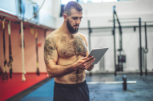 man logging workouts in notebook | how to improve focus