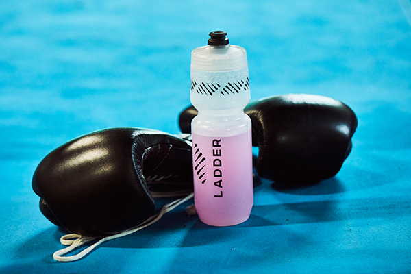 bottle of ladder pre-workout next to boxing gloves