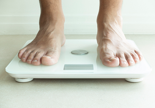 man weighing himself on scale | creatine loading