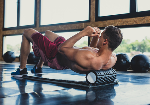 man foam rolling upper back | how to recover faster from workout