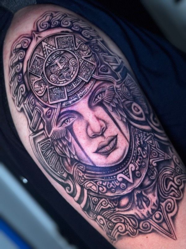 Black and grey ornamental Aztec warrior tattoo on upper arm