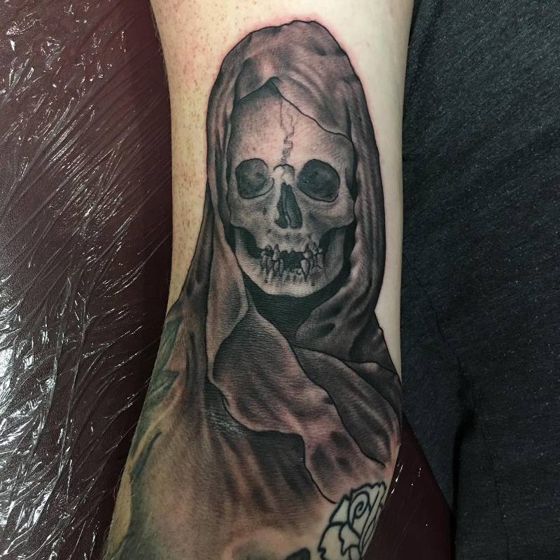 Black and grey realistic grim reaper skull on forearm