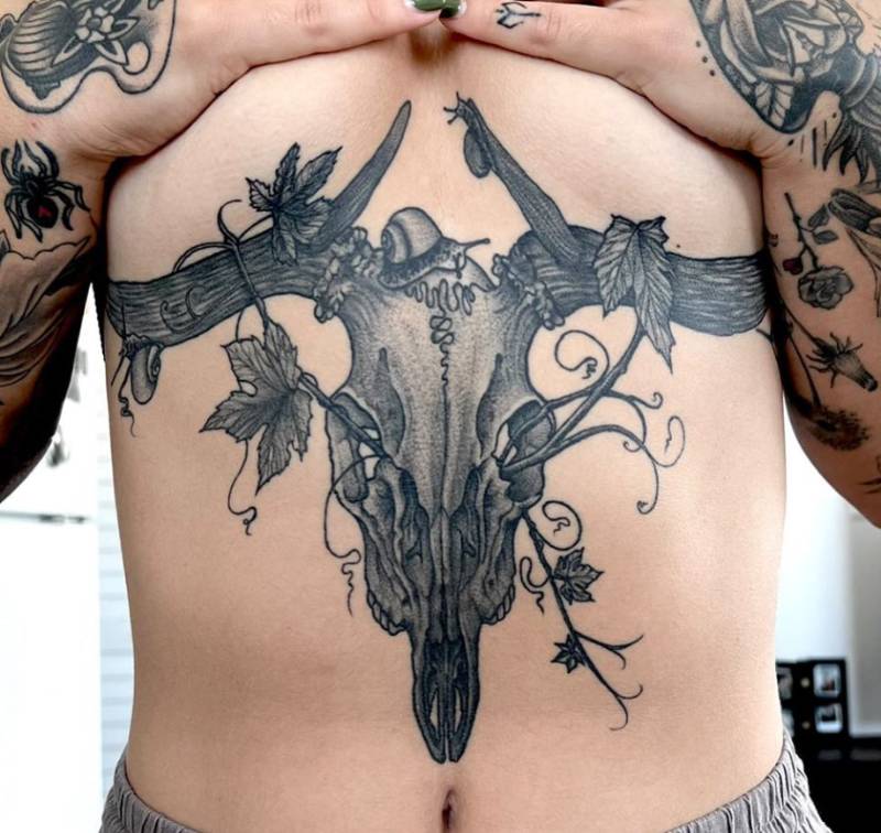 Black and grey realistic deer skull with leaves tattoo on torso