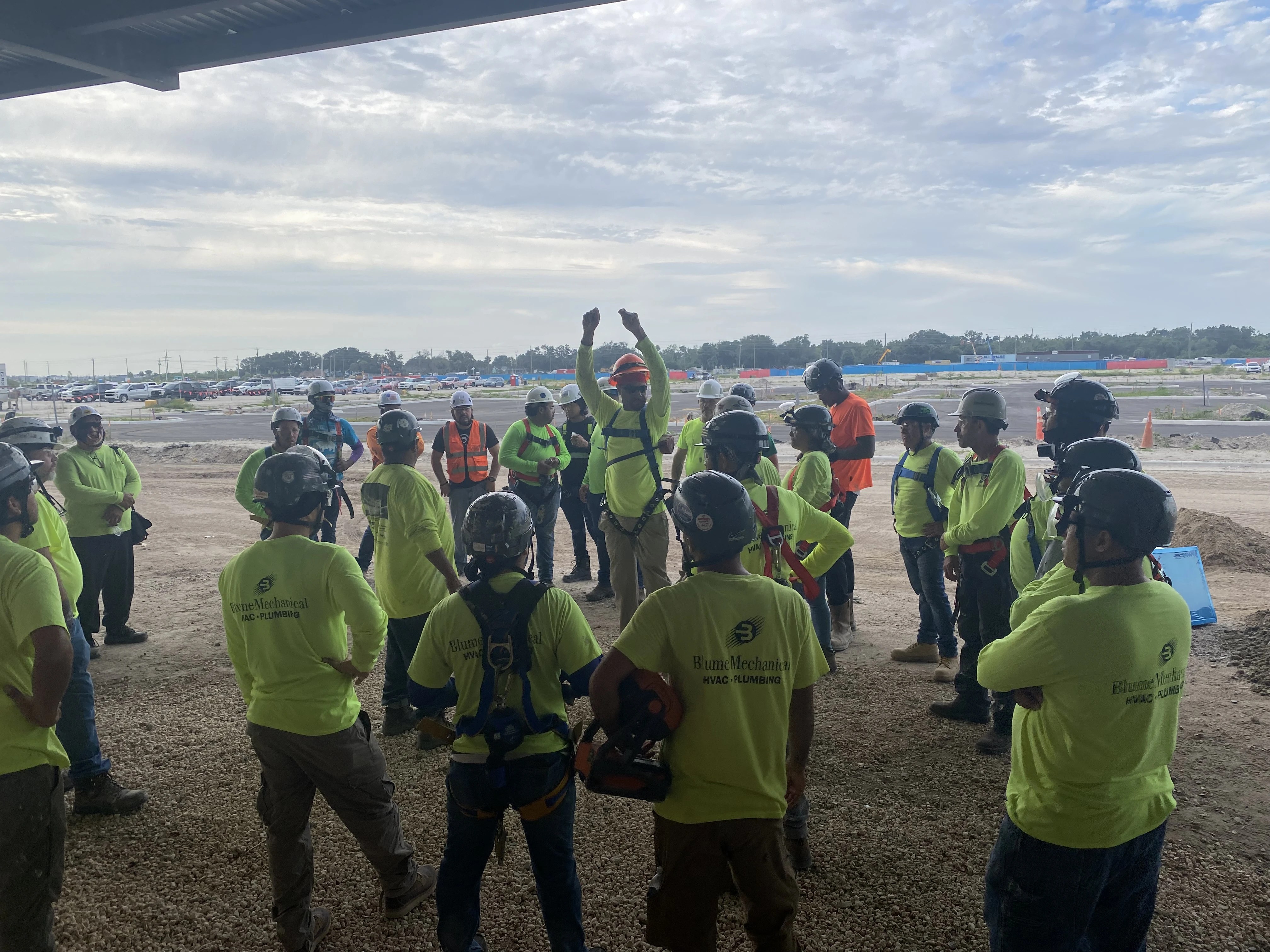 Blume Mechanical field crew gathered in a circle for a jobsite briefing