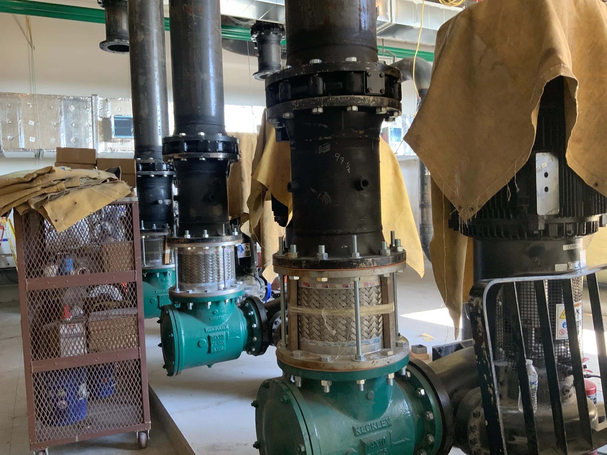 Green pumps and black flanged piping connections during installation at BayCare Manatee