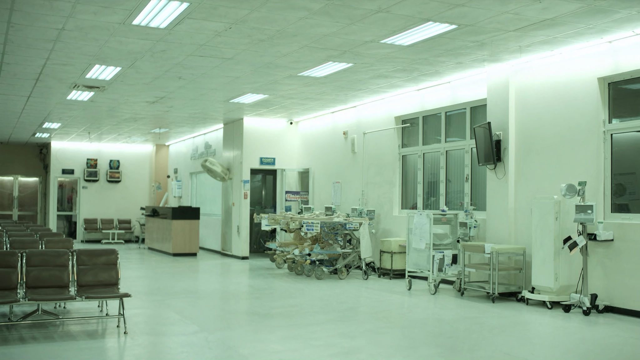 Troli pesakit dan kerusi menunggu di koridor jabatan kecemasan sebuah hospital awam pada waktu malam