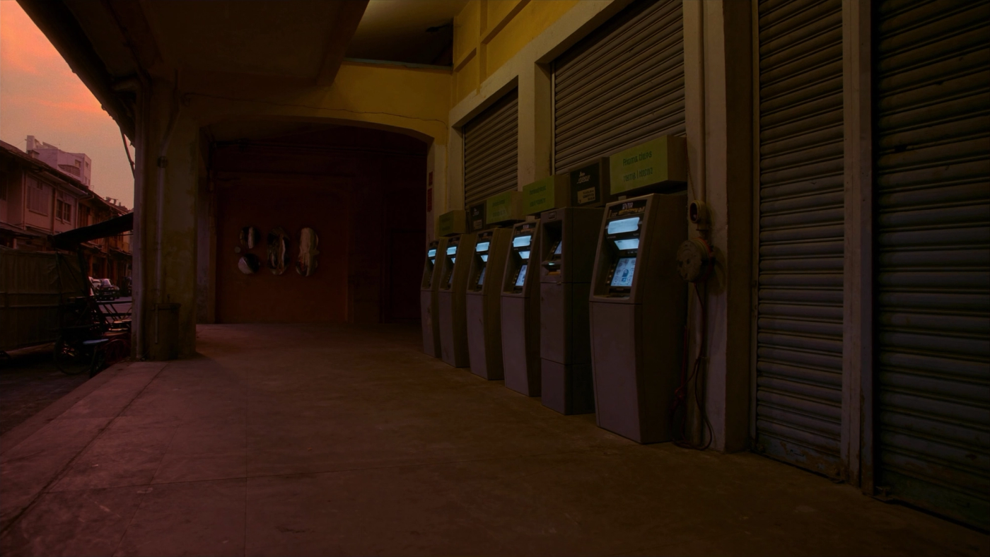 Deretan mesin ATM kosong di kaki lima deretan kedai lama pada waktu senja.