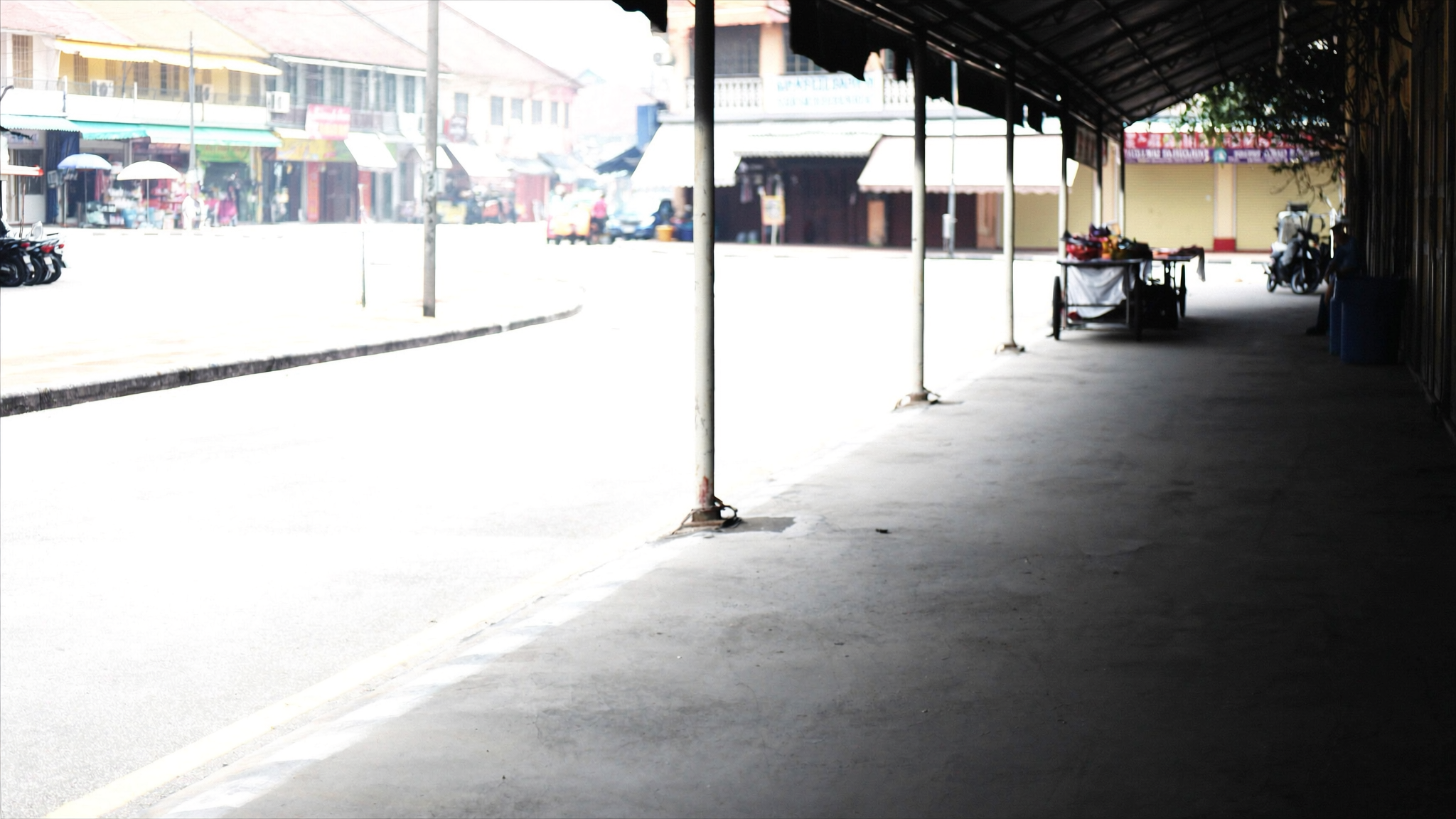 Jalan bandar di Malaysia pada waktu tengah hari dengan cahaya matahari terik dan udara berbahang