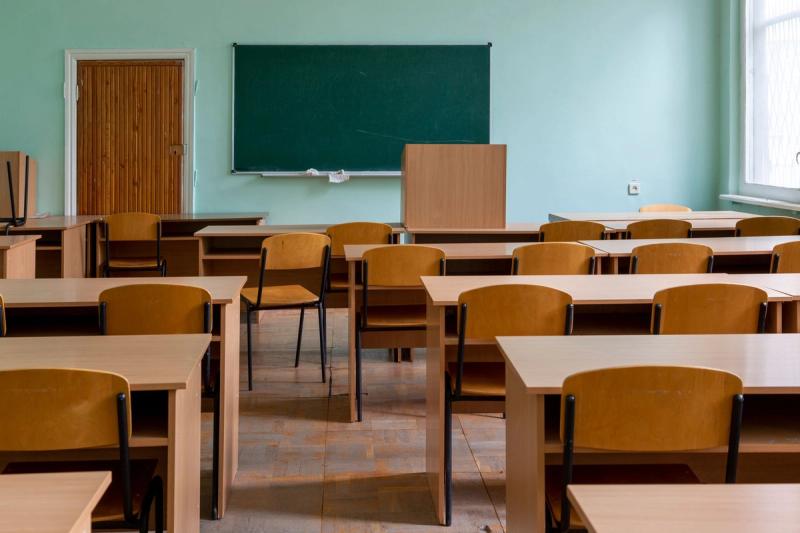 Ruang bilik darjah kosong dengan papan hitam dan meja murid yang tersusun