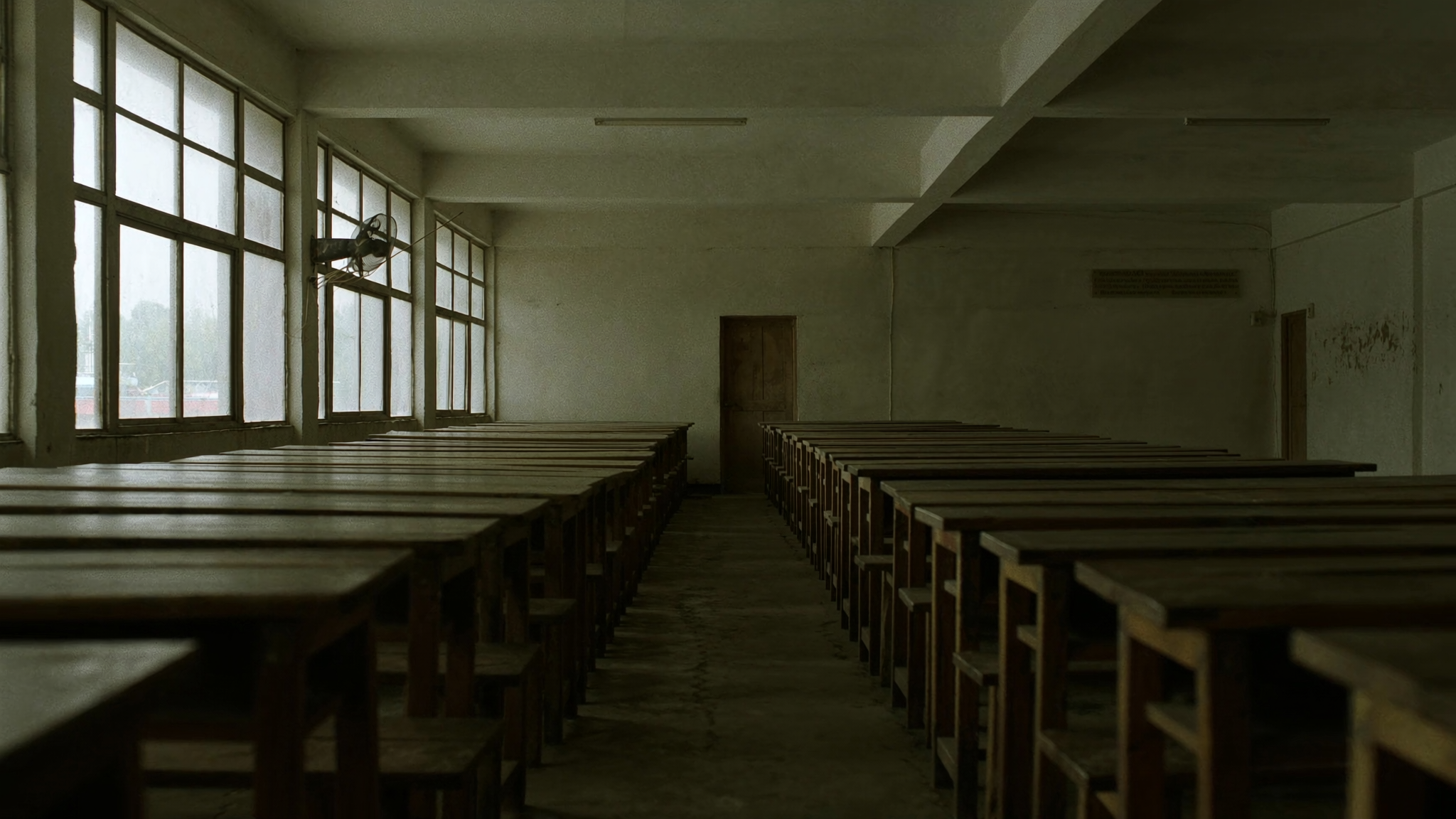 Barisan meja dan kerusi tersusun rapat di dalam sebuah bilik darjah yang sesak tanpa murid