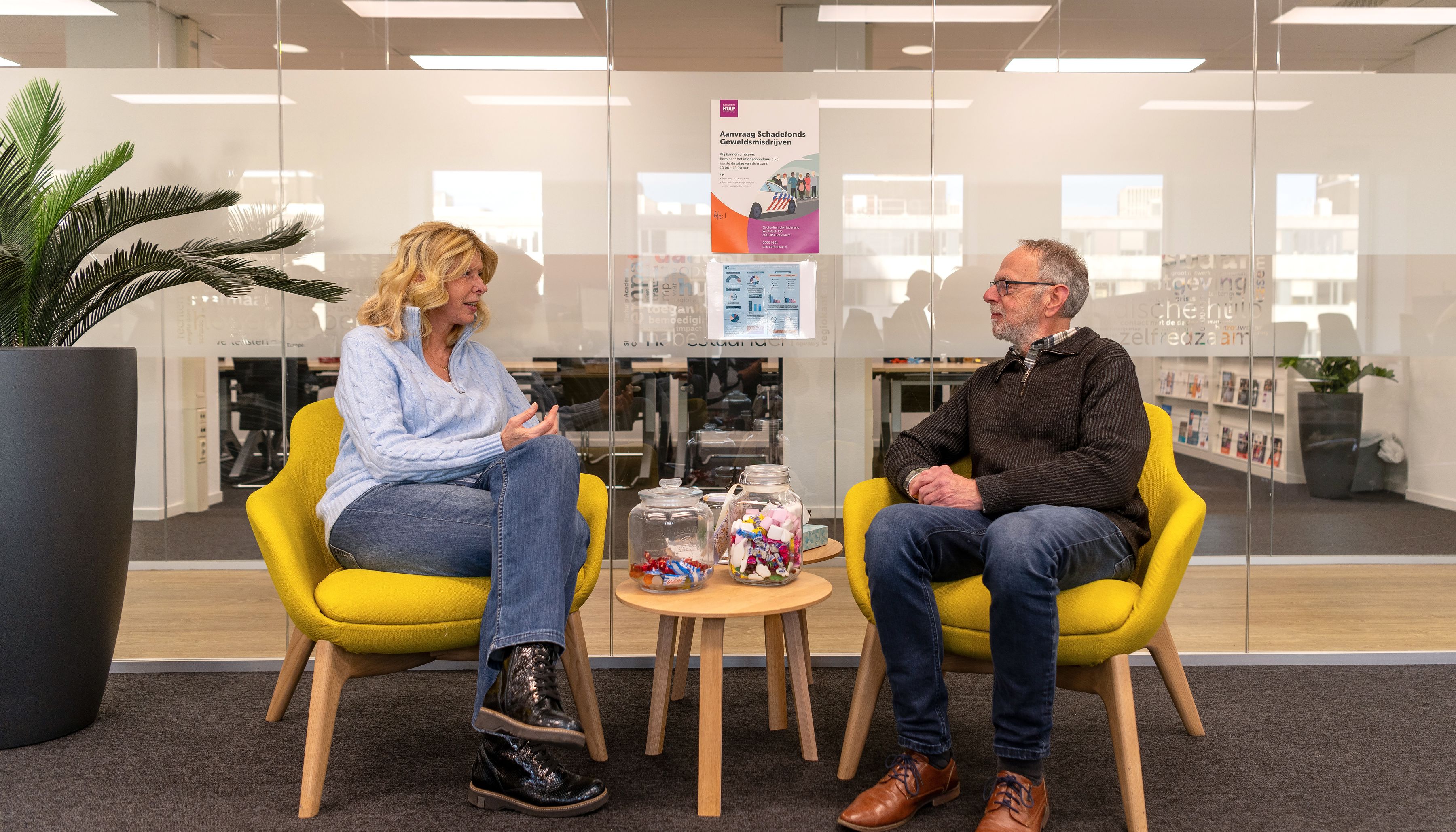 2 medewerkers in gesprek in een stoel