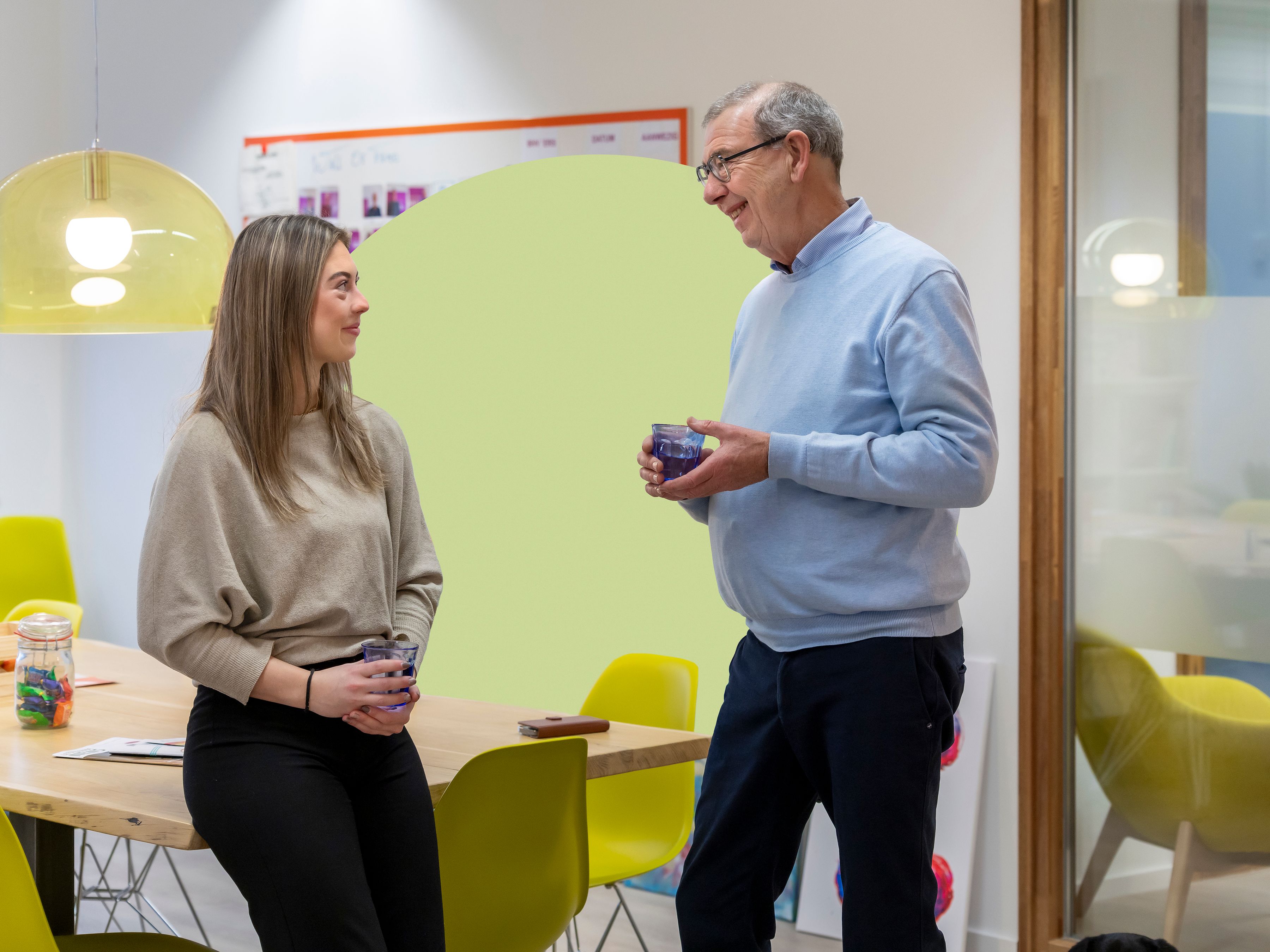 Foto van Cris in gesprek met collega op kantoor
