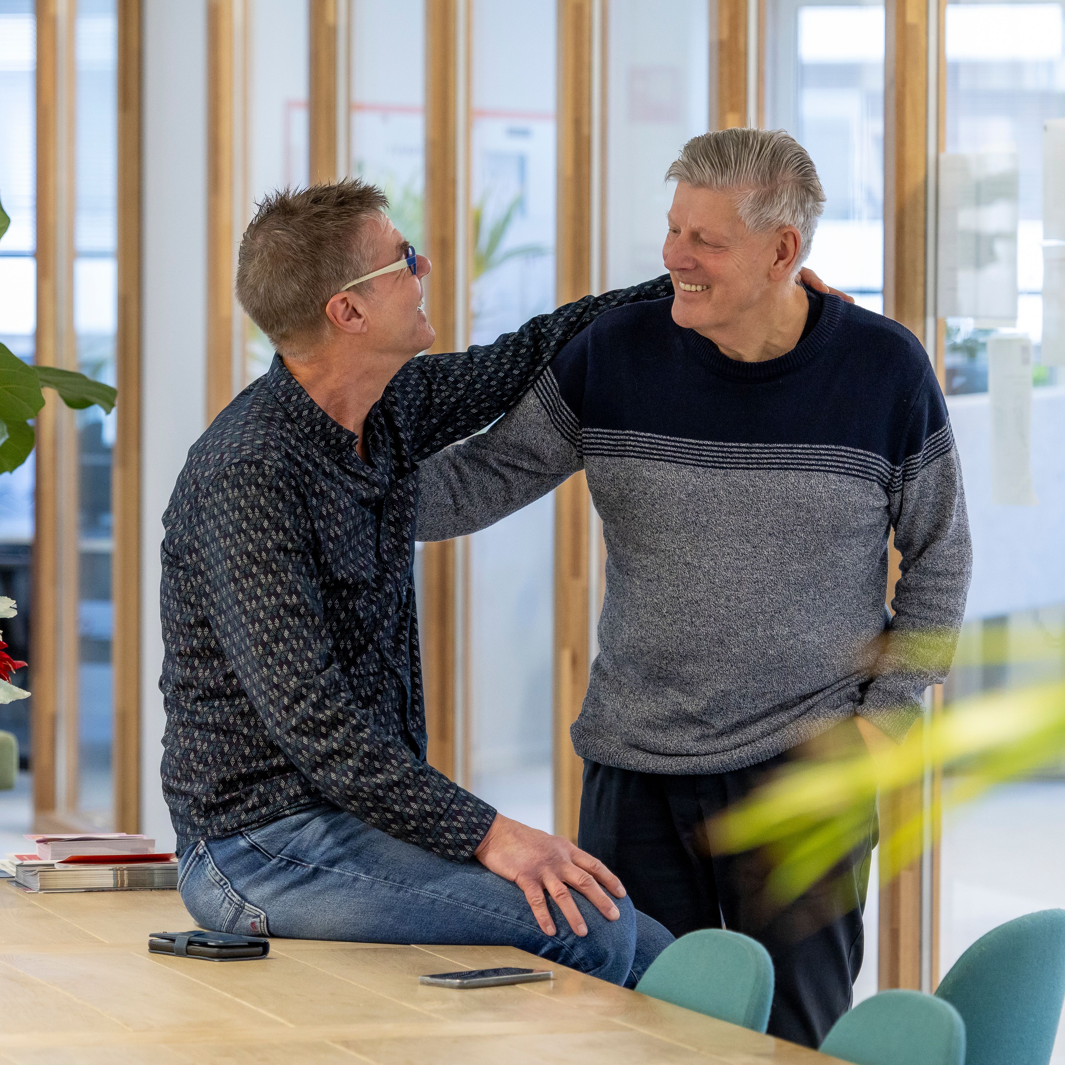 2 medewerkers die elkaar vriendelijk begroeten