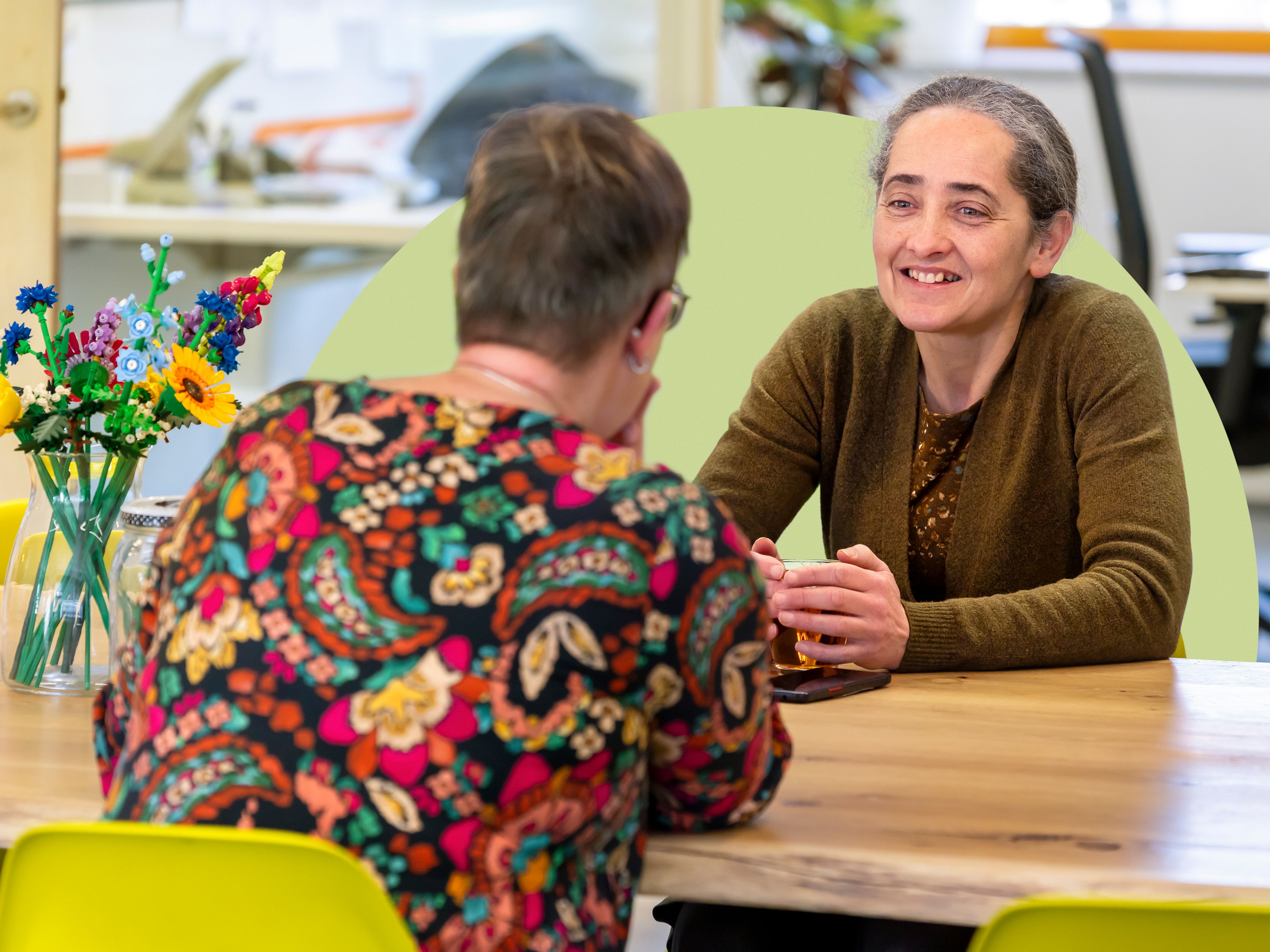 Petra in gesprek met collega op kantoor